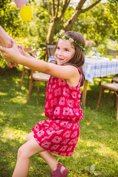 girl pulling adult's arm in garden - garden decoration stock pictures, royalty-free photos & images