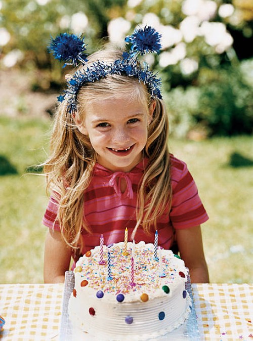 girl sitting at a table with her birthday cake - garden decoration stock pictures, royalty-free photos & images