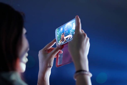 Girl used mobile phone camera take pictures In the Concert party