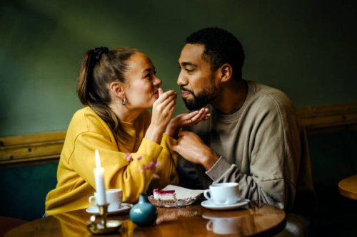 girlfriend feeding bite of dessert to her boyfriend at cafe - food stock pictures, royalty-free photos & images