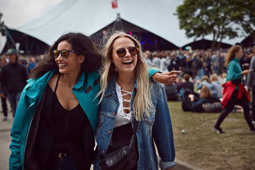 girlfriends laughing together at outside festival - concert stock pictures, royalty-free photos & images