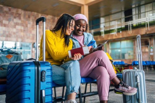 girlfriends using mobile phone at the airport - travel stock pictures, royalty-free photos & images