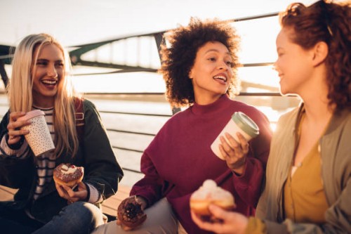 girls drinking coffee and eating donuts - junk food stock pictures, royalty-free photos & images