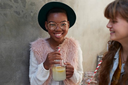 girls sitting on staircase & drinking lemonade - fashion stock-fotos und bilder