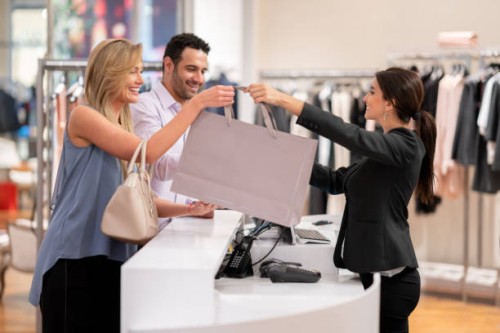 glückliches paar an einem bekleidungsgeschäft einkaufen - fashion stock-fotos und bilder