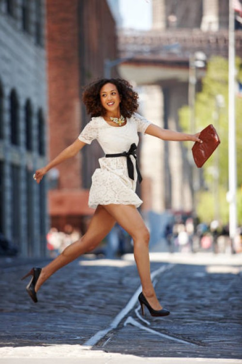 glamorous mixed race woman running on urban street - fashion stock pictures, royalty-free photos & images