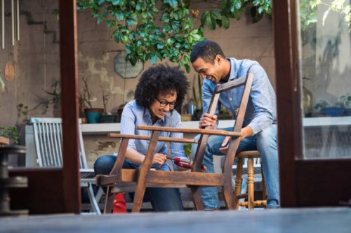 glimlachend jong koppel werken samen om te herstellen van een stoel - home decoration stockfoto's en -beelden