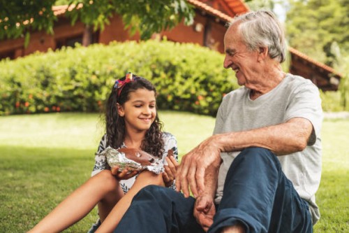 grandfather and granddaughter eating chocolate - garden decoration stock pictures, royalty-free photos & images