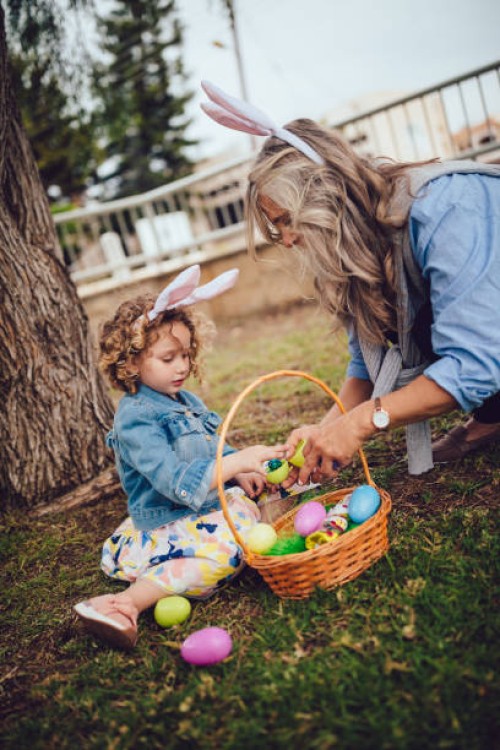 grandmother and little granddaughter celebrating easter with easter egg hunt - garden decoration stock pictures, royalty-free photos & images