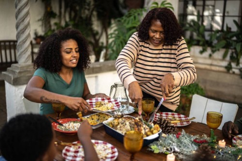 grandmother serving food to family during christmas lunch outdoors at home - garden decoration stock pictures, royalty-free photos & images