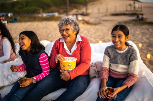 grandmother with grandchildren watching a movie at the outdoors cinema - concert stock pictures, royalty-free photos & images