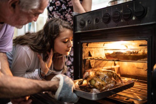 grandparents and granddaughter checking the traditional turkey for christmas dinner - food stock pictures, royalty-free photos & images