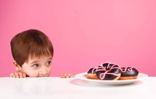 greedy boy looking at doughnuts - junk food stock pictures, royalty-free photos & images