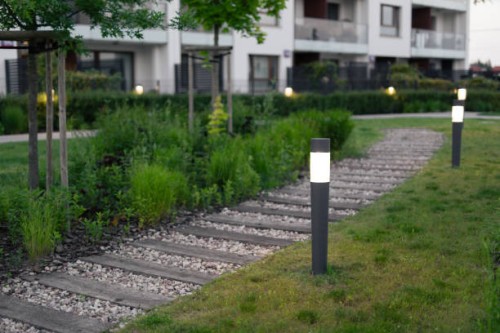 green building. lamps by the footpath in an elegant courtyard at evening. - garden decoration stock pictures, royalty-free photos & images