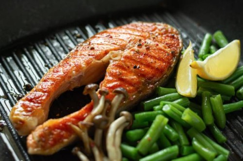 grilled salmon steak, baked piece of trout with green beans, shimeji mushrooms and lemon in a grilled pan. - junk food stock pictures, royalty-free photos & images