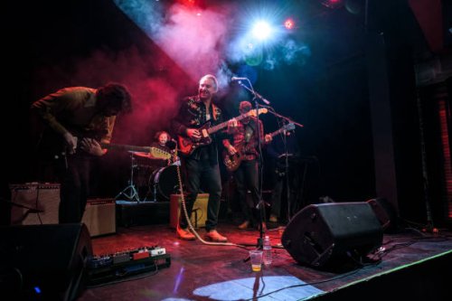 grinning musicians performing on stage - concert stock pictures, royalty-free photos & images