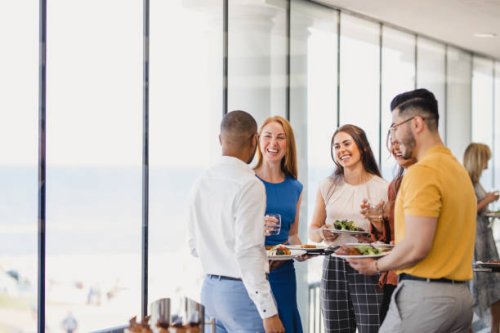 group of cheerful colleagues enjoying lunch break at event - food stock pictures, royalty-free photos & images