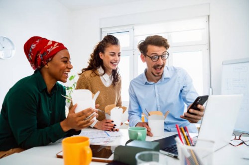 group of colleagues using mobile phone during office break time - junk food stock pictures, royalty-free photos & images