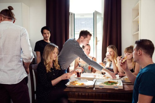 group of friends chatting over drinks and pizza at home - junk food stock pictures, royalty-free photos & images