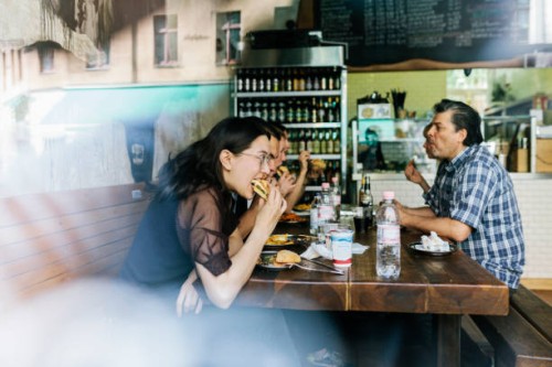 group of friends eating burgers together - junk food stock pictures, royalty-free photos & images