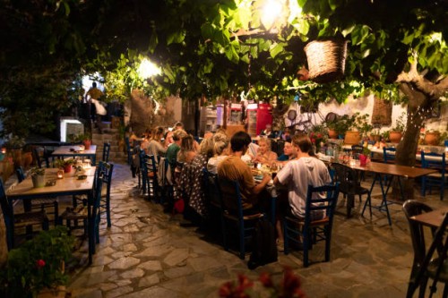 group of friends eating dinner in mediterranean courtyard - food stock pictures, royalty-free photos & images