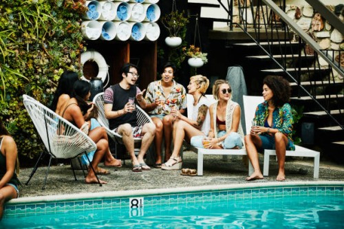 group of friends in discussion during party by pool hotel - fashion stock pictures, royalty-free photos & images
