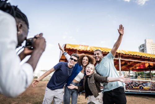 group of friends posing for photo at amusement park - concert stock pictures, royalty-free photos & images