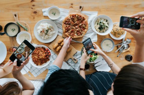group of friends taking pictures of food on the table with smartphones during party - food stock pictures, royalty-free photos & images