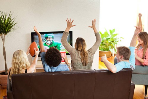 group of friends watching and cheering football game together - home decoration stock pictures, royalty-free photos & images