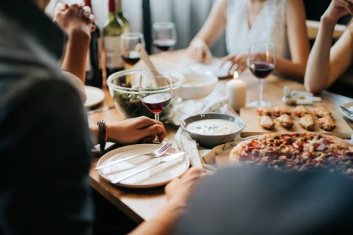 group of joyful young asian man and woman having fun, enjoying food and wine across table during party - food stock pictures, royalty-free photos & images