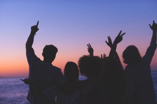 group of people partying on the beach at sunset or sunrise. - concert stock pictures, royalty-free photos & images