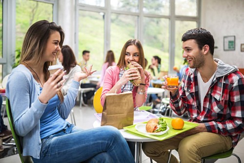 group of students communicating during lunch in cafeteria. - food stock pictures, royalty-free photos & images