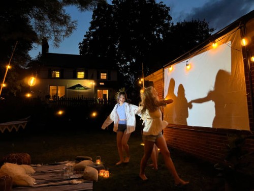 group of teenagers dancing in front of a glowing screen for outdoor movies - garden decoration photos et images de collection