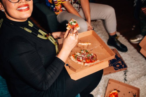 group of young people sharing pizza at a party - junk food stock pictures, royalty-free photos & images