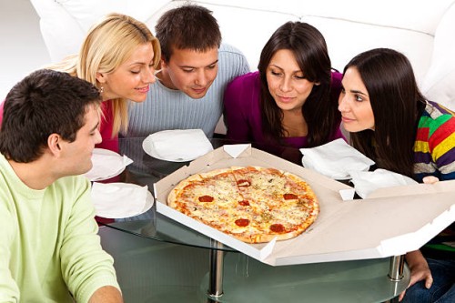 group of young students preparing to eat pizza - junk food stock pictures, royalty-free photos & images