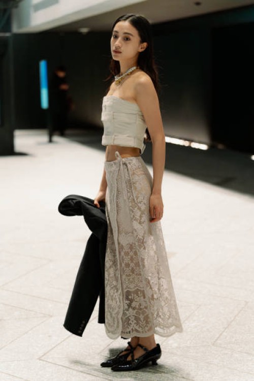 Guest is seen wearing a beige top, beige maxi lace skirt, black shoes during Rakuten Tokyo Fashion Week A/W 2025 on March 19, 2025 in Tokyo, Japan.