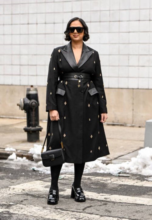 Guest is seen wearing a black and gold embellished coat, black bag, black shoes and black sunglasses outside the Michael Kors show during NYFW F/W...