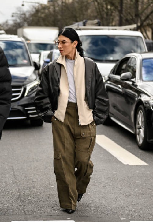 Guest is seen wearing a black jacket, cream jacket, white shirt, green cargo pants outside the Miu Miu show during the Womenswear Fall/Winter...