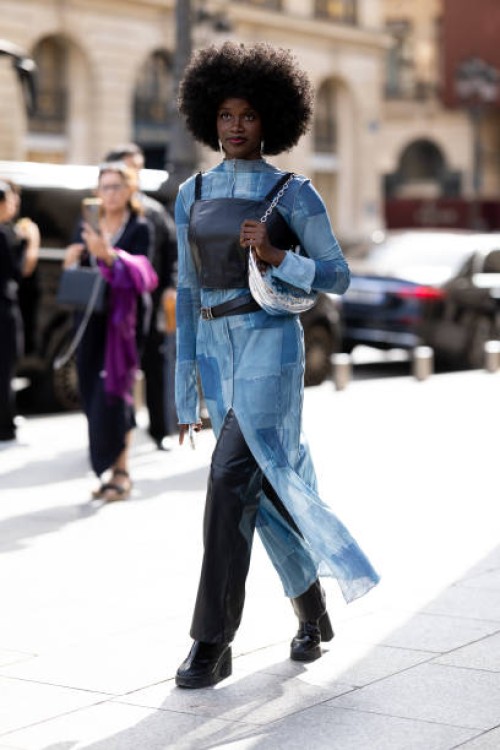 Guest is seen wearing a black leather tank top over a denim patchwork dress outside Giambattista Valli show during the Womenswear Spring/Summer 2024...