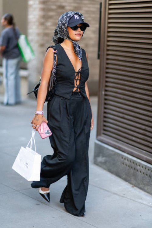 Guest is seen wearing a black top, black pant, black and cream heels, black bandana and black hat outside the Patbo show during New York Fashion Week...
