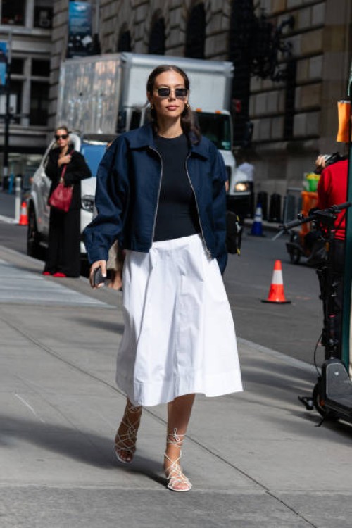 Guest is seen wearing a blue jacket, blue top, white skirt and white sandal outside the Carolina Herrera show during New York Fashion Week on...