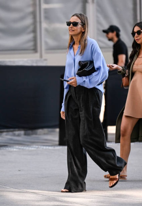 Guest is seen wearing a blue shirt, black bag , black pants and brown shoes outside the Michael Kors show during NYFW Spring/Summer 2025 on September...