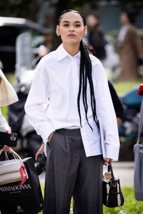 Guest, is seen wearing a oversize white shirt and grey trousers outside Fendi show during the Milan Fashion Week Menswear Spring/Summer 2025 on...