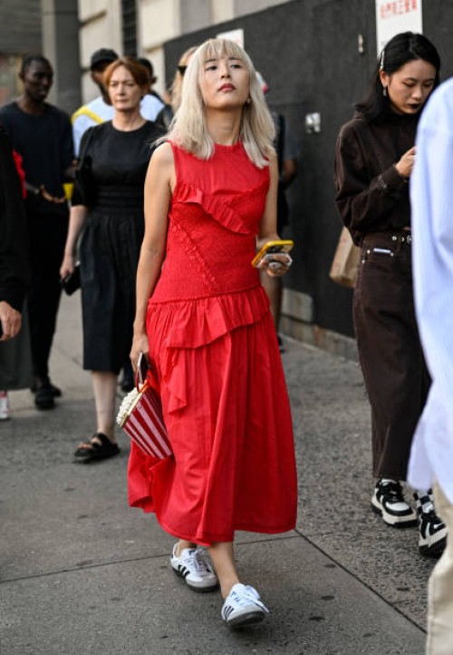 Guest is seen wearing a red dress and white Adidas sneakers with a popcorn bag outside the 3.1 Phillip Lim show during NYFW S/S 2024 on September 10,...