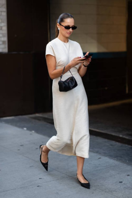 Guest is seen wearing a white dress, black shoes, black sunglasses and carrying a black bag outside the Patbo show during New York Fashion Week on...