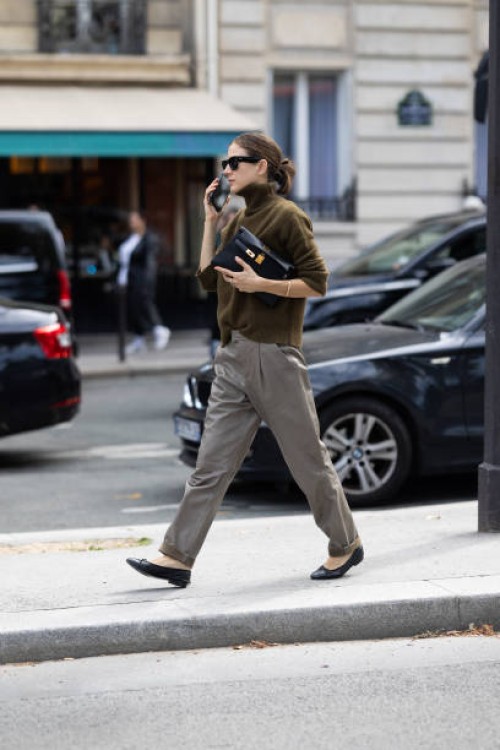 Guest is seen wearing black leather ballerinas, grey trousers, a kaki long sleeved sweater, a black leather bag and black sunglasses outside Chloe...