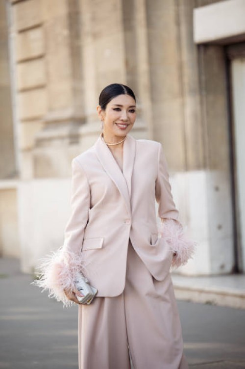 Guest is seen wearing light pink powder color suit with feather sleeves outside the Nina Ricci show during Paris Fashion Week - Womenswear Fall...
