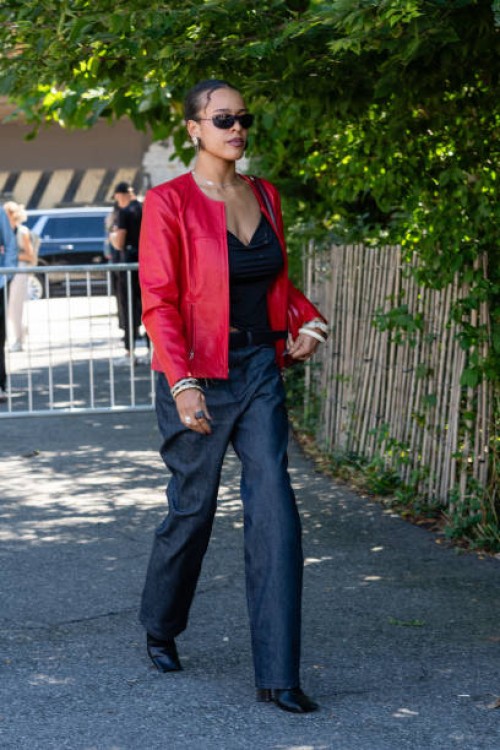 Guest is seen wearing red jacket, black top, dark blue denim pant, black boots, black sunglasses and carrying a red bag outside the Off-White show...