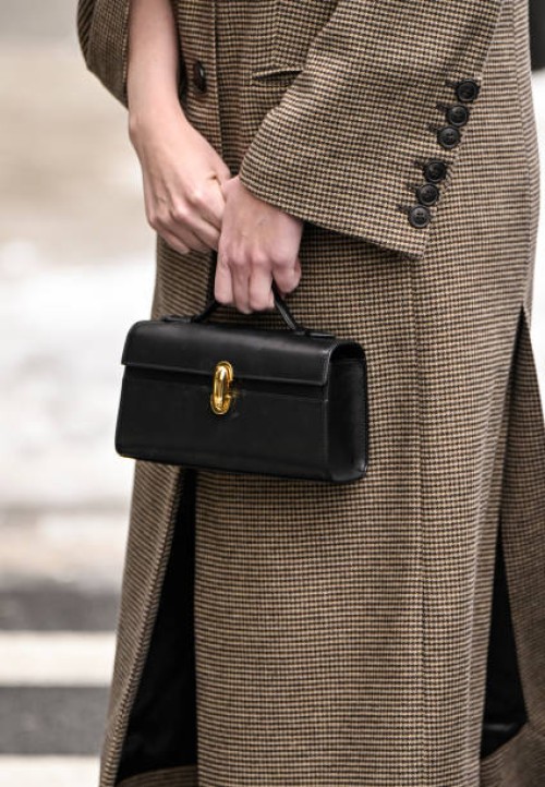 Guest is seen with a black and gold buckle bag outside the Ulla Johnson show during NYFW F/W 2025 on February 09, 2025 in New York City.