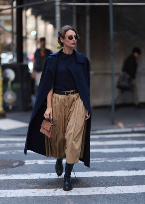 Guest seen wearing a dark blue shirt, matchy dark blue long jacket, beige brown wide pants, Carolina Herrera brown leather handbag and black belt,...